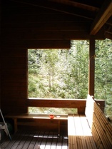 Pääsulakkeiden kaappi näkyy tarkkaan tihrustaen terassin päädystä metsän reunassa.